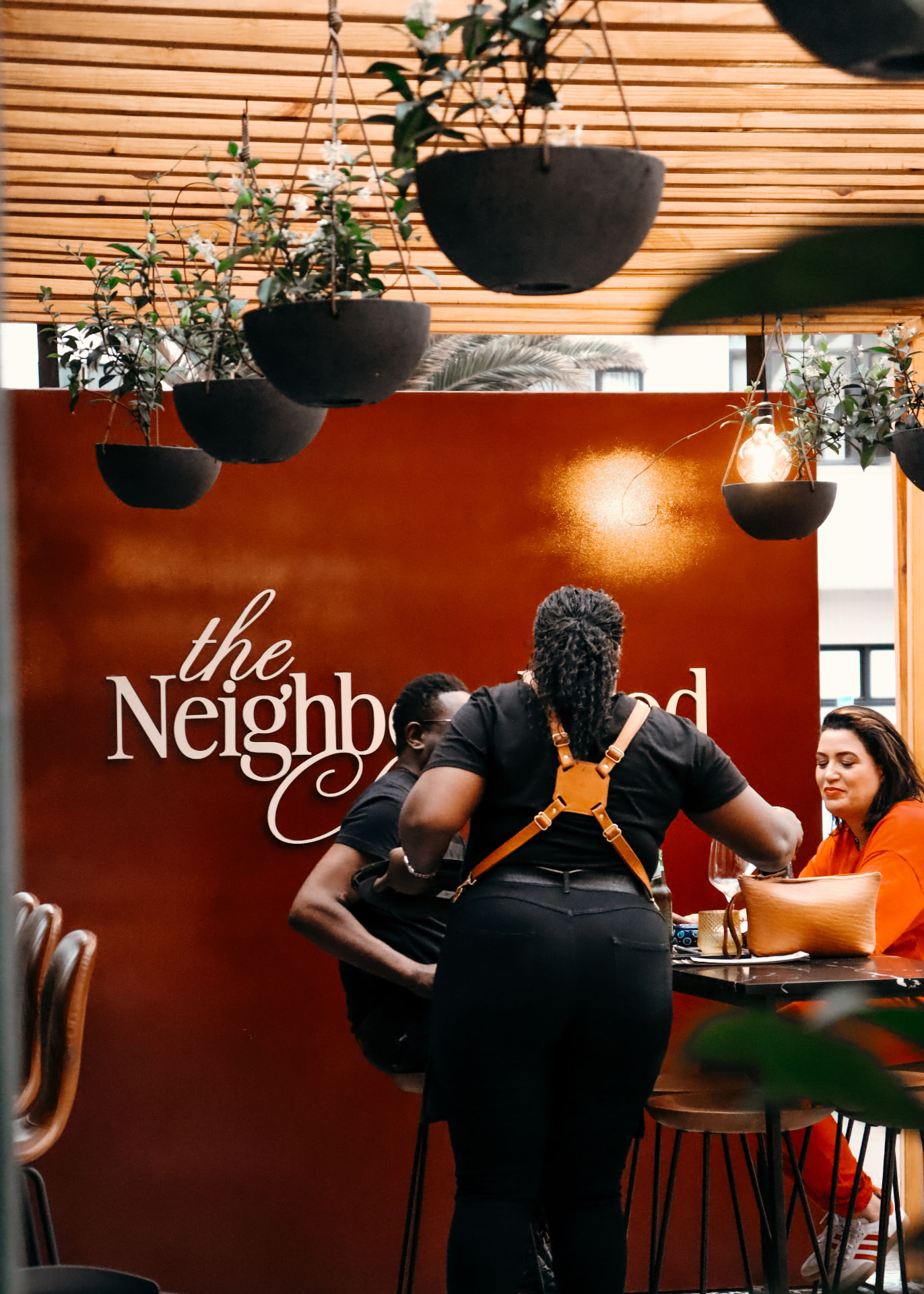 Guests at the high tables beside the burgundy wordmark wall