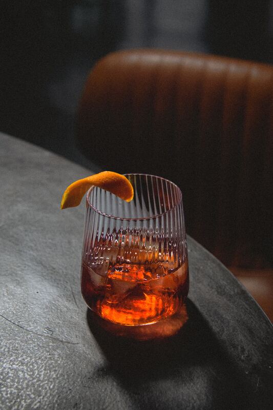 Negroni with orange twist on a stone table