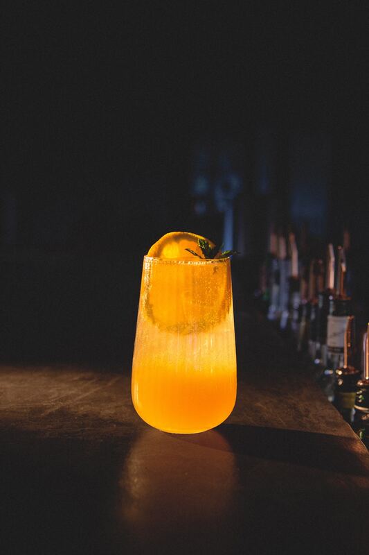 Tall citrus highball on the bar counter