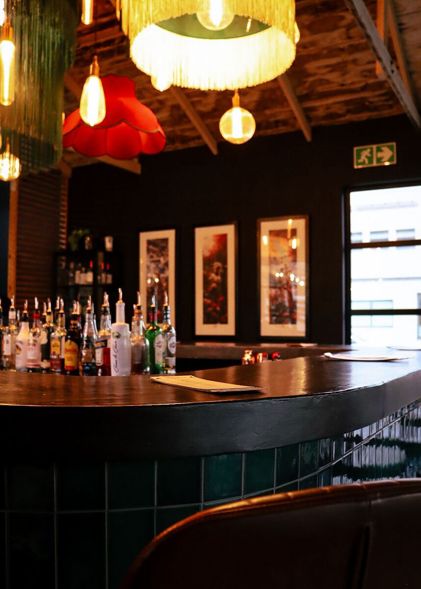 The curved bar top at The Neighbourhood Club under low tungsten light